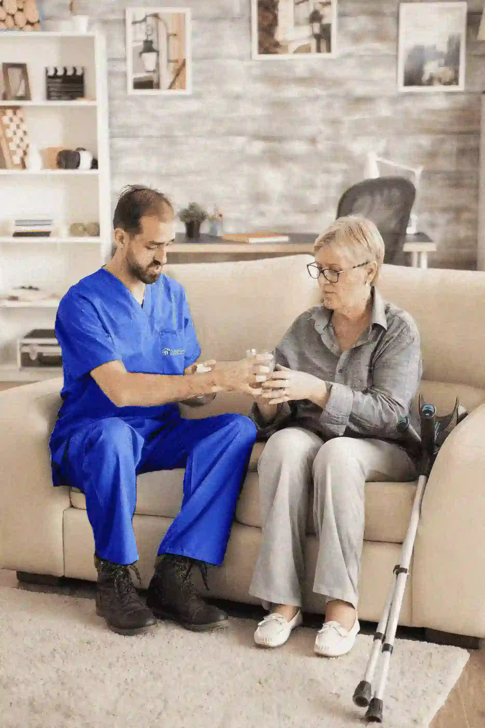 A woman in a wheelchair receives help from a nurse, showcasing a moment of care and assistance.