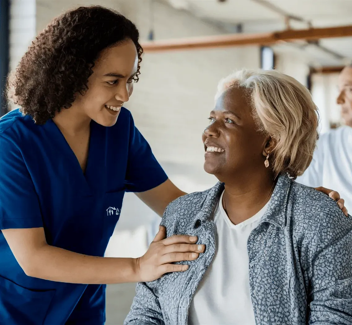 A caring nurse interacts with an elderly man in a nursing home, highlighting the importance of support and companionship