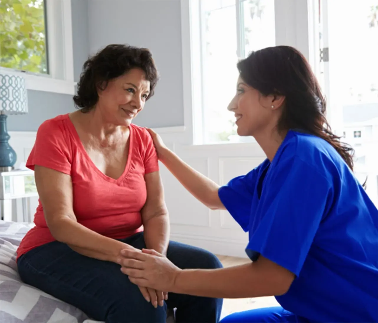 another nurse assiting an elderly woman