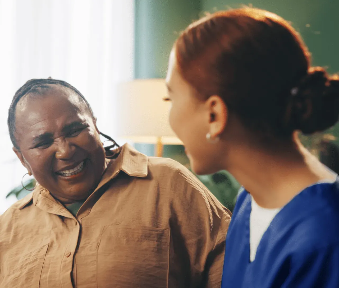 nurse and elderly woman laughing